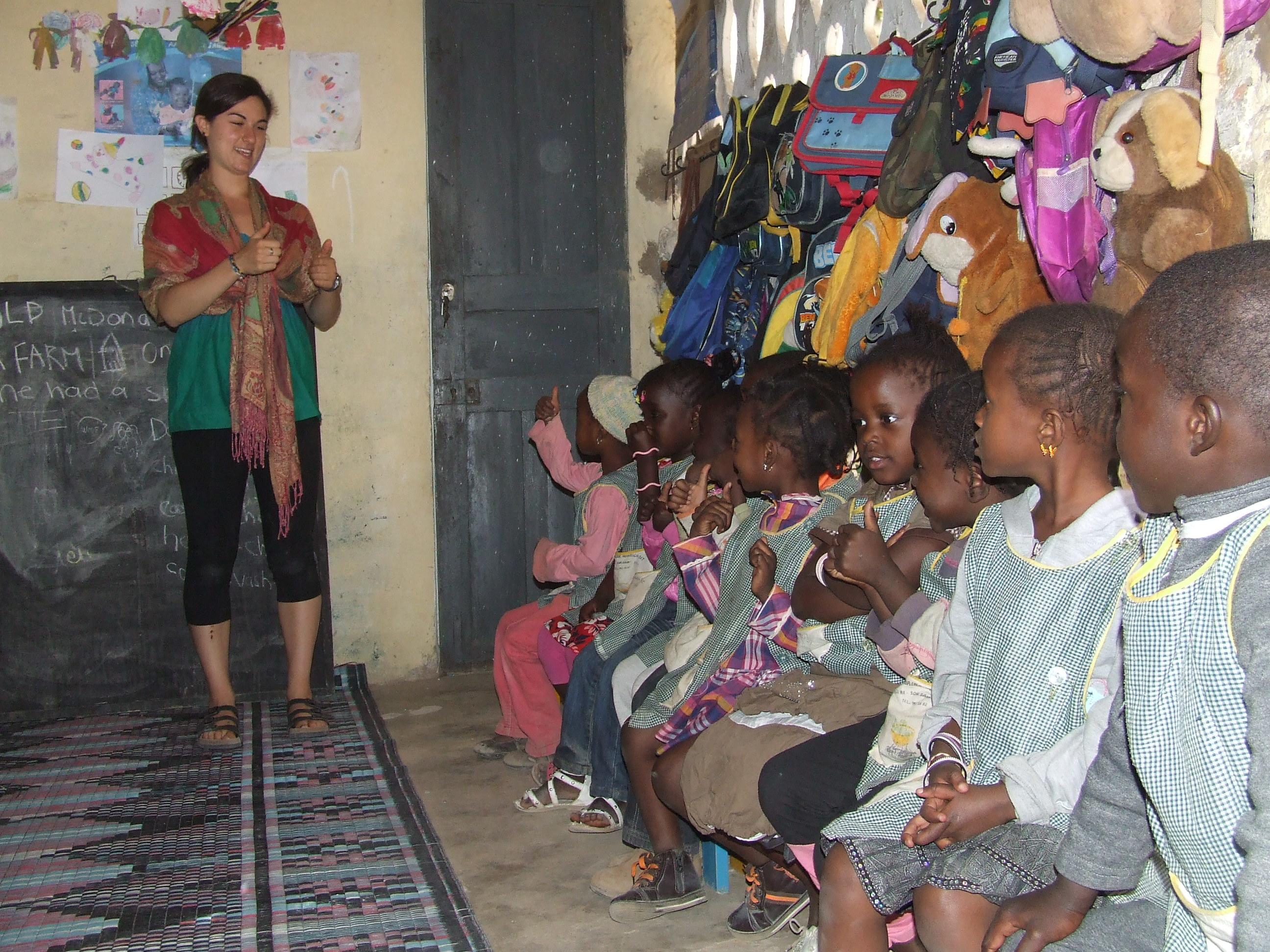 A volunteer speaks to children at a care centre in Senegal A volunteer works with children in senegal on a project made for teenagers